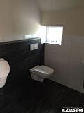 Toiletruimte met hangend toilet en zwarte wandtegels