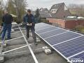 Monteurs plaatsen zonnepanelen op een plat dak